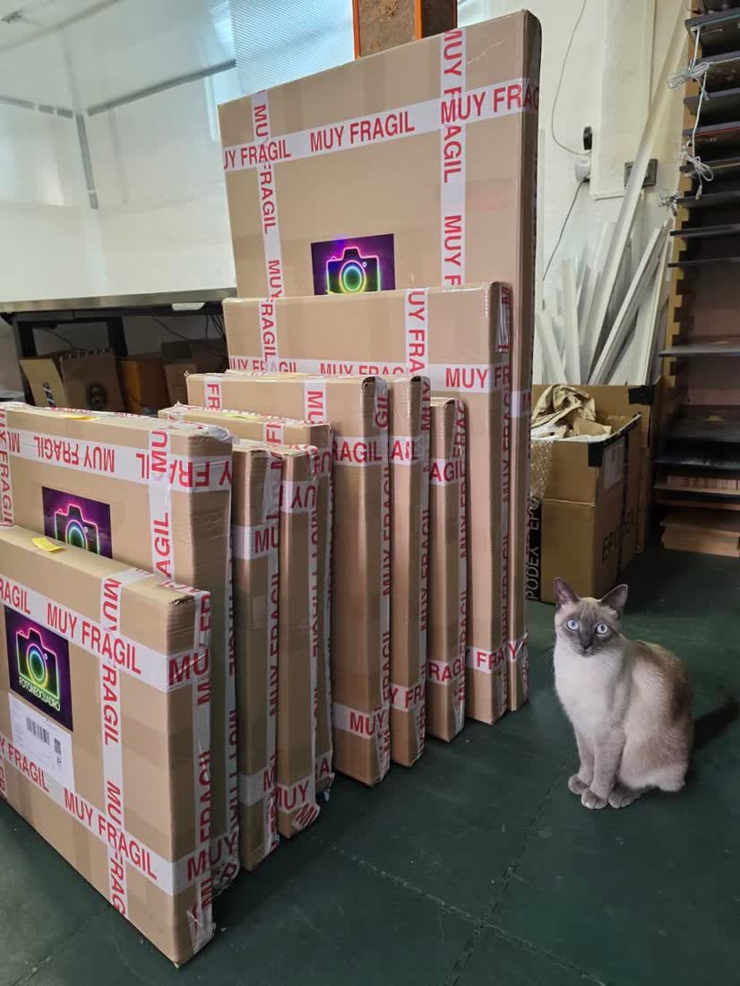 Pila de cuadros de resina epoxi ya embalados en cajas con cinta de muy fragil, listos para enviar desde el taller