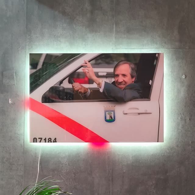 Cuadro recto con la foto de un taxista en su vehículo